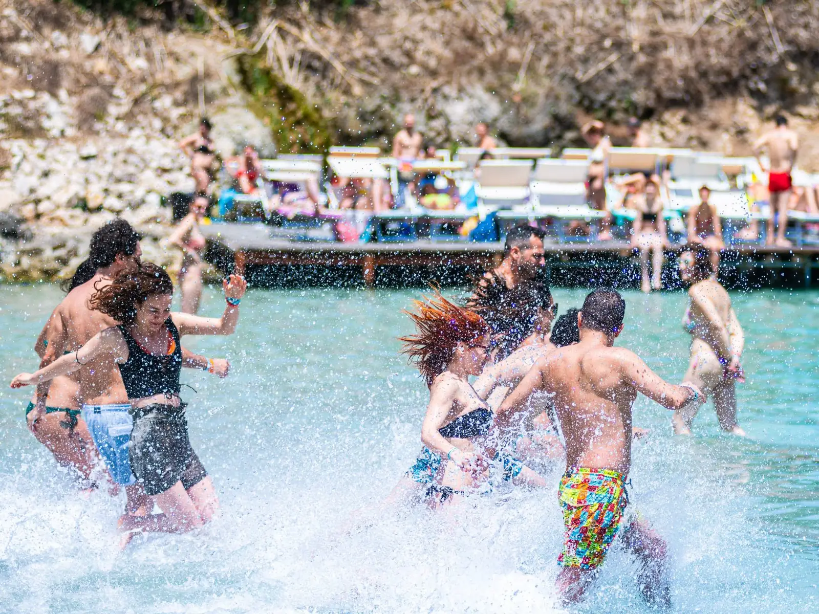 Dancers running into the sea in a burst of splashes, during the Festival